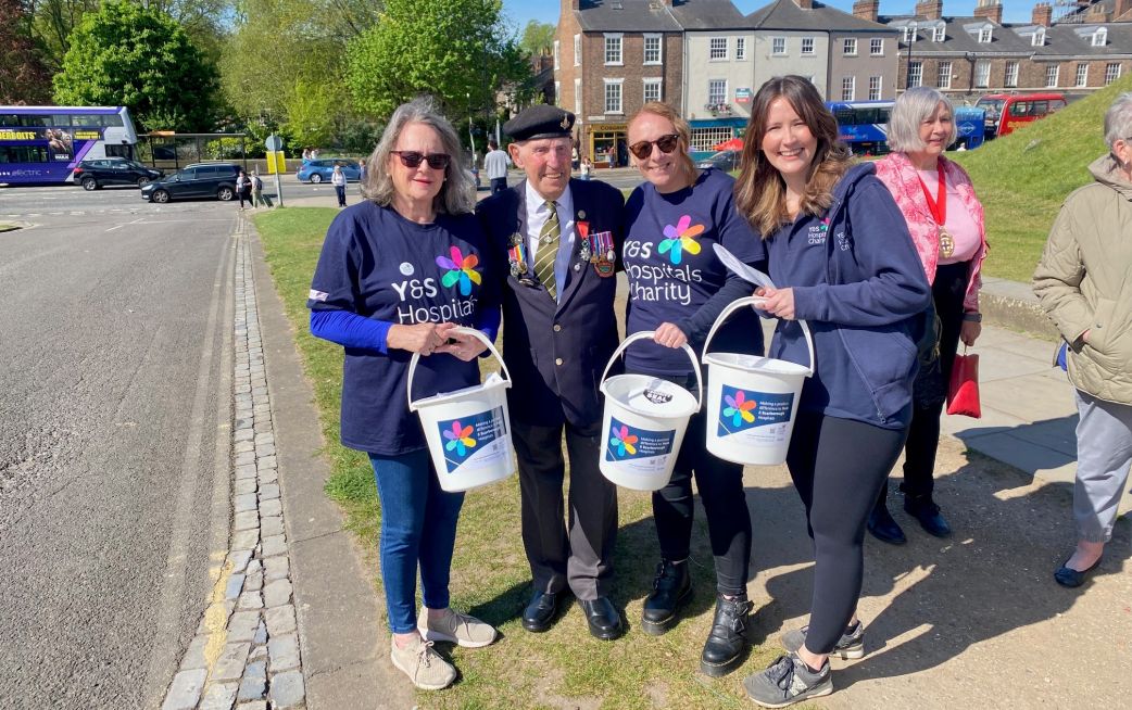 Charity bucket collectors smiling holding charity buckets