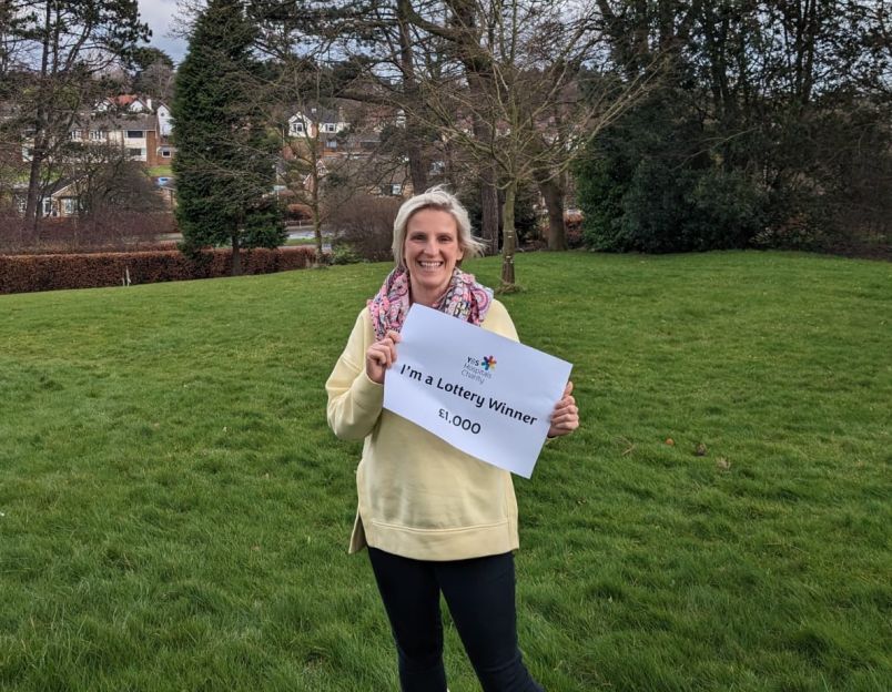 lottery winner holding sign saying 