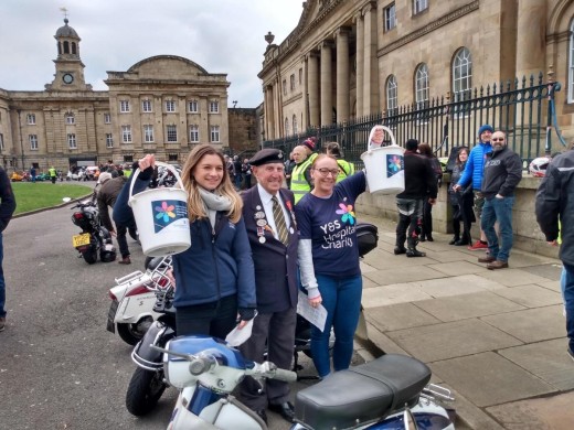 Two charity bucket collectors smiling with Ken Cooke, the president of the York Inset Scooter Club