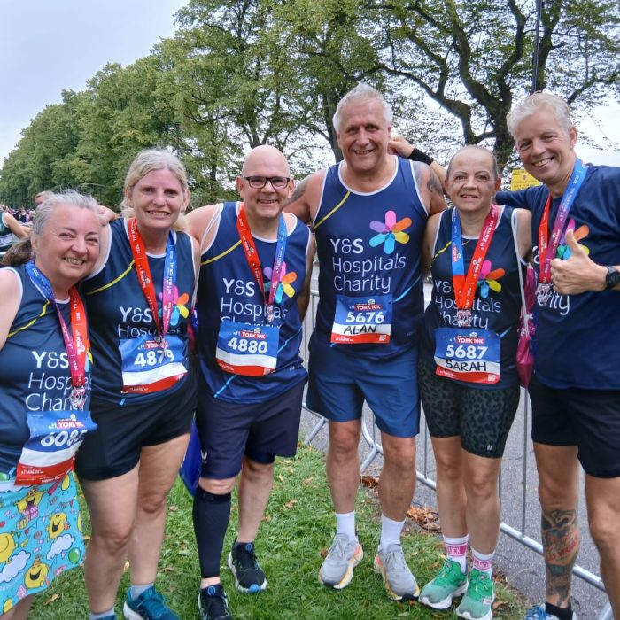 Group of runners posing with medals after completing the York 10k