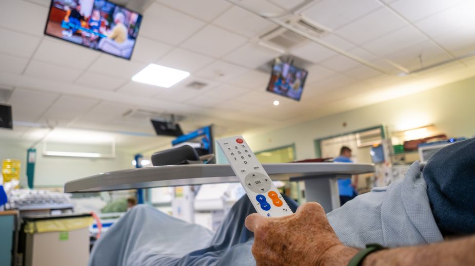 Patient Ray holding tv remote whist receiving dialysis 